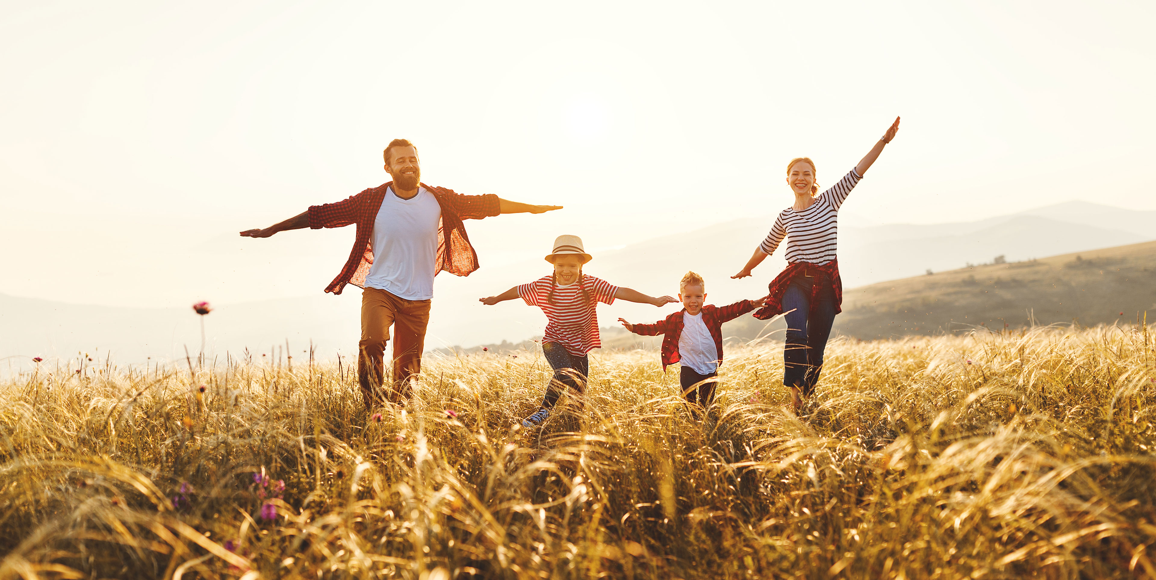 Family skipping in a field. 